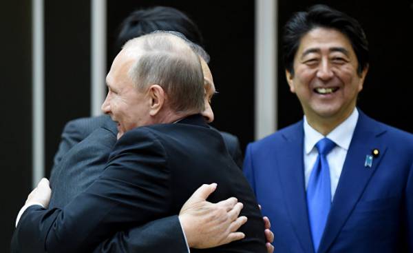 Президент России Владимир Путин обнимается с бывшим премьер-министром Японии Ёсиро Мори